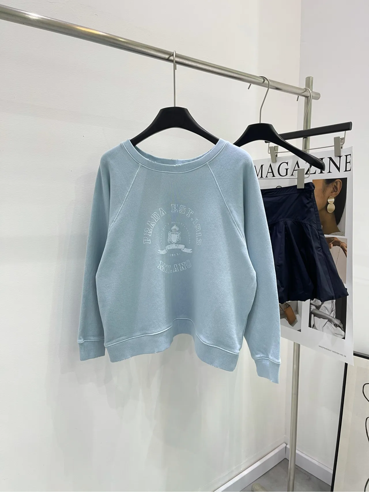 薄い青で古いアルファベットプリントの丸首のパーカー